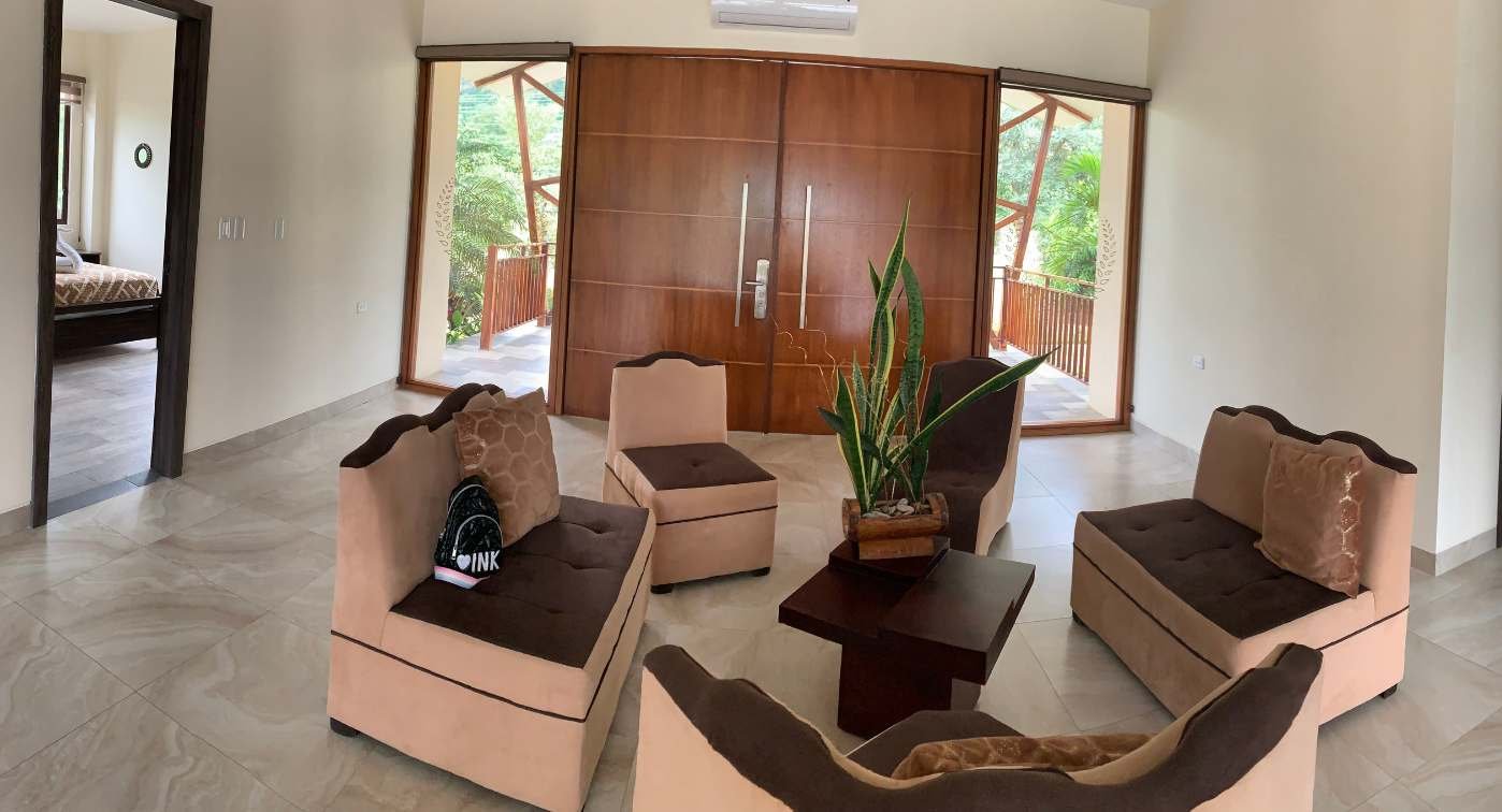 Sala de casa con mesas y una entrada grande.
