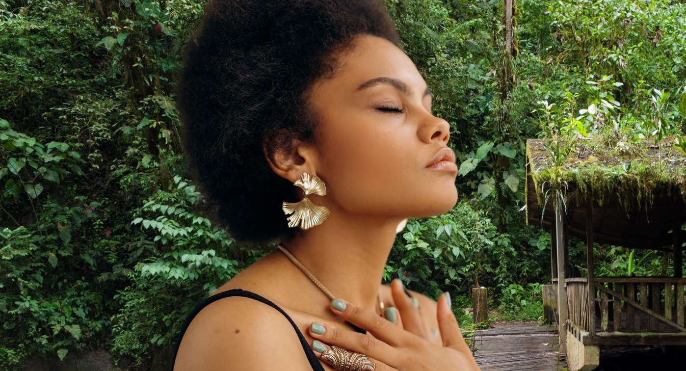Woman holds heart in nature.